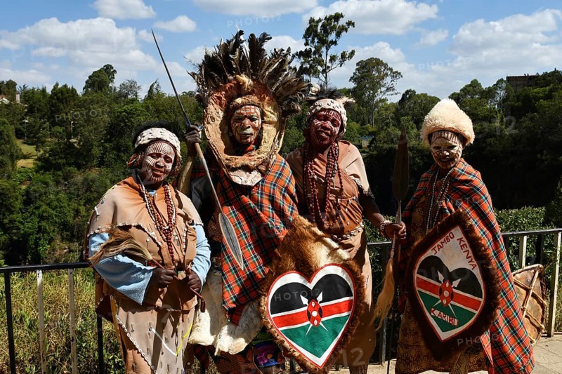 Kikuyu dancer with face paint poses for photographers at Nyahururu Falls