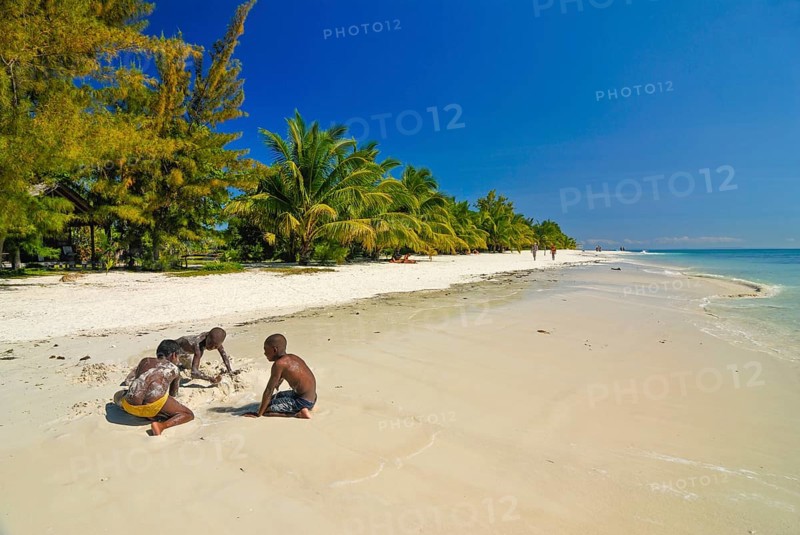 Children playing on a white sand beach on Iles aux Nattes near Ile saint marie