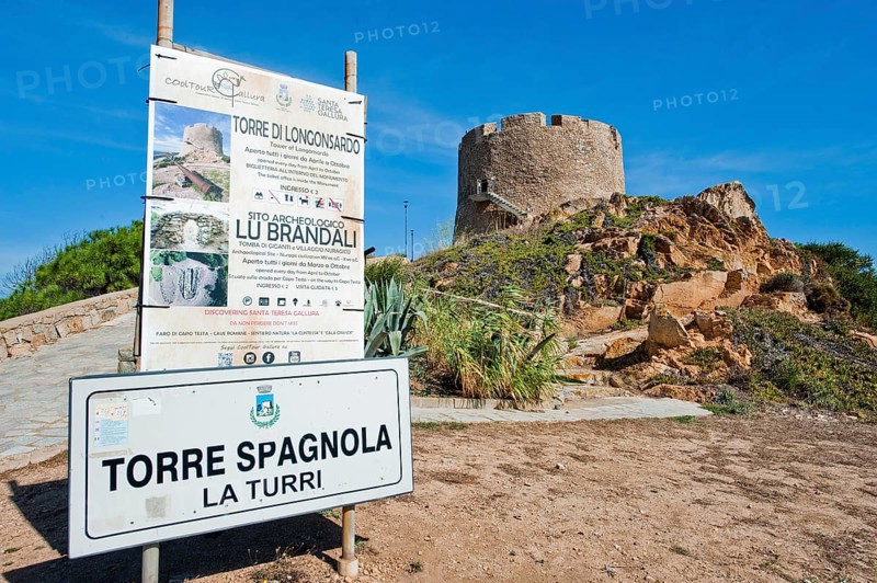 Left tourist information sign Sign for in the background historical Spanish fortified defence tower Torre Spagnola La Turri