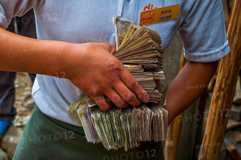 Woman holds bundles of Yuan