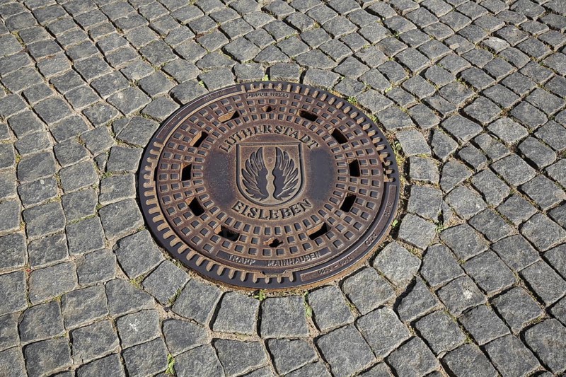 Manhole cover with paving stones on the ground