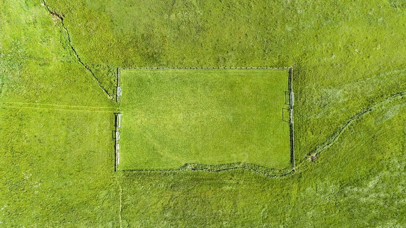 Aerial view of a football field in the Allgaeu region with a stream as a sideline