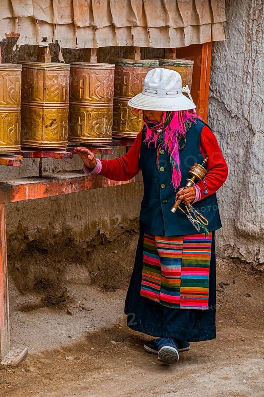 Old woman turning the prayer wheels in the kingdom of Guge