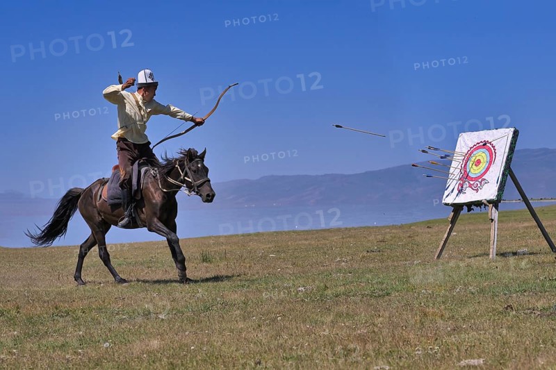Kyrgyz nomad shooting arrows on a target while galloping