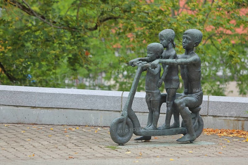 Sculpture with three children on a scooter