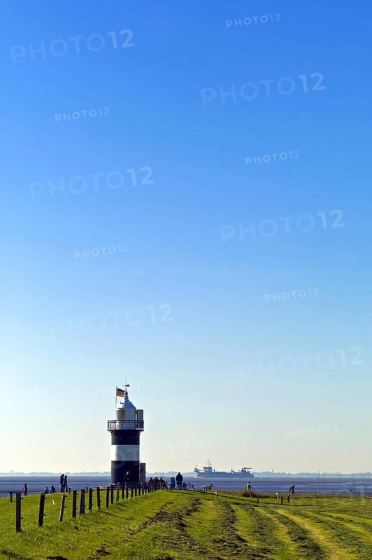 Wremertief in the district of Cuxhaven. Kleiner Preusse lighthouse and freighter on the Aussenweser