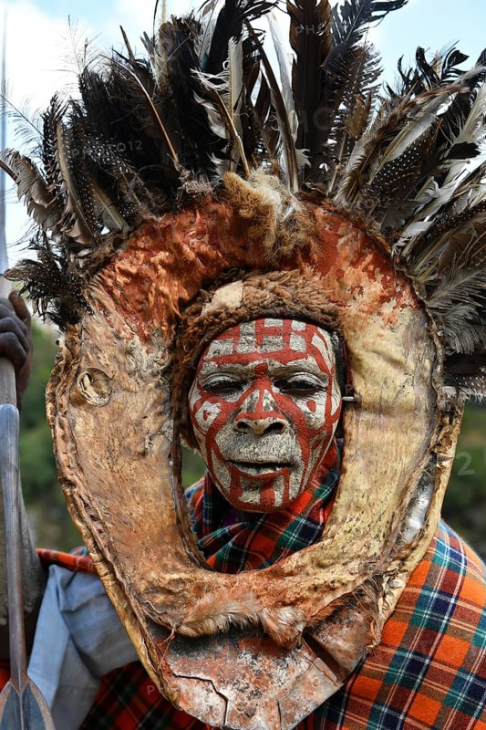 Kikuyu warrior with face paint poses for photographers at Nyahururu Falls
