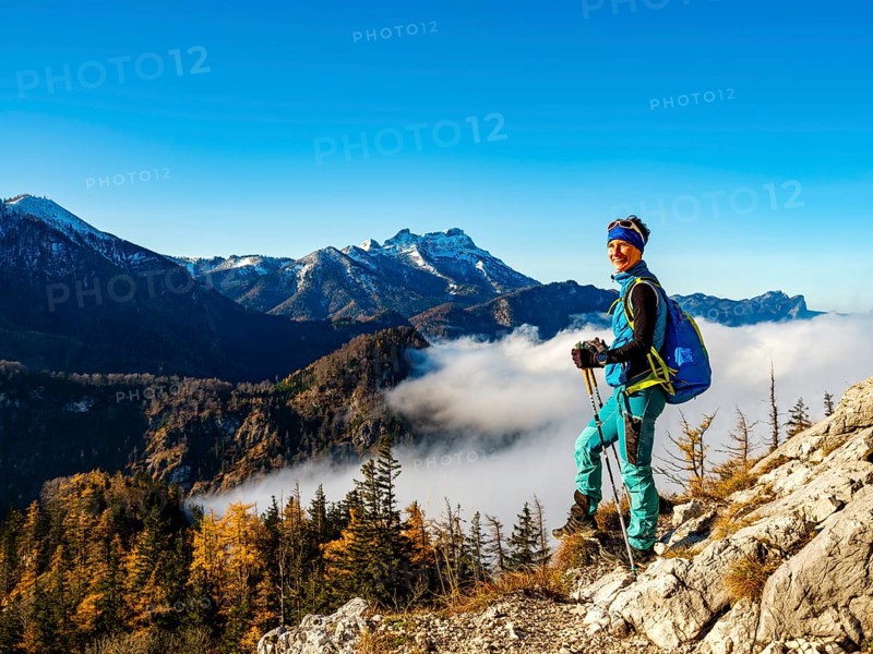 Mountaineer above forest line and clouds enjoying the view
