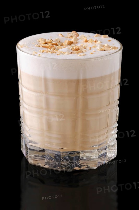 Cappuccino or latte with hazelnut crumbs on black background with reflection