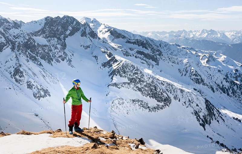 Hiker looking at Stubai Alps from Mitterzeigerkogel