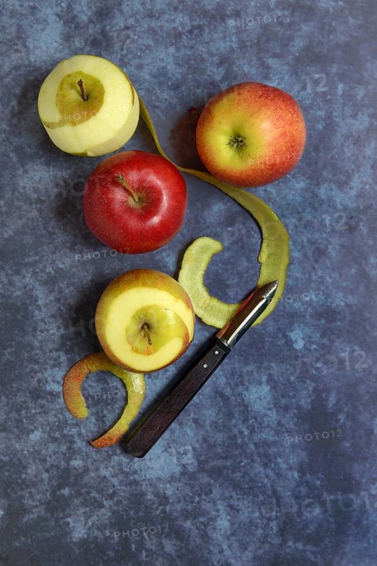 Peeled apples with peeling knife