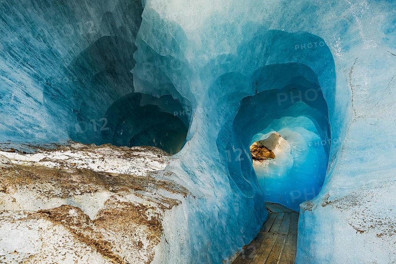 Visitors Wooden footbridge through ice tunnel in the Rhone glacier