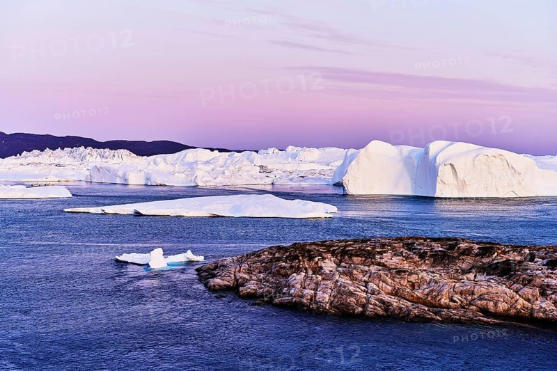 Gigantic icebergs in the light of the blue hour