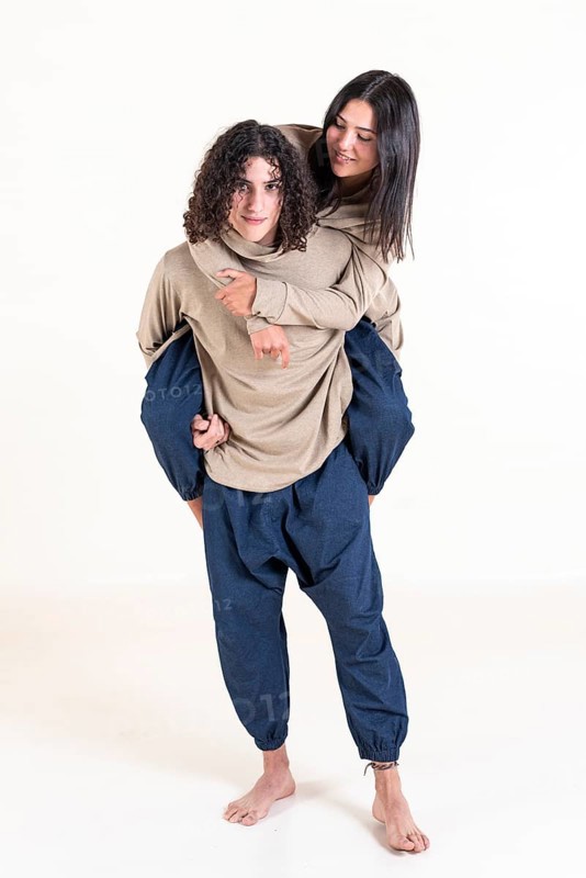 Brother and sister twins matching outfits. A handsome teenager carrying his beautiful sister on his back