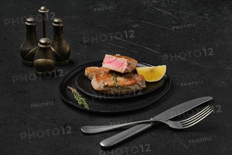 Fried tuna steak on black background