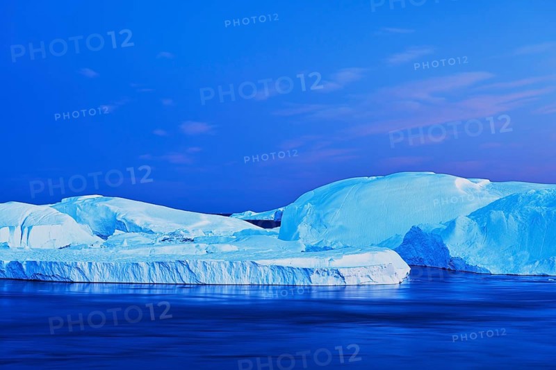 Gigantic icebergs in the light of the blue hour