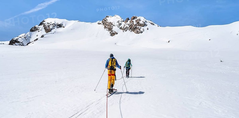 Ski tourers walking on the rope on the glacier