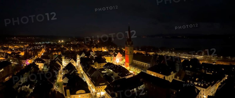 Aerial view of the town of Radolfzell on Lake Constance at night with the Minster Tower illuminated at Christmas
