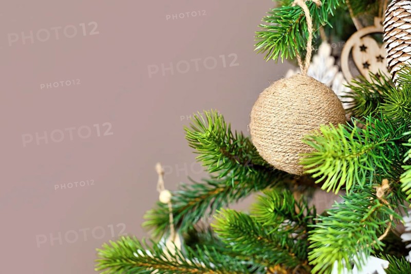 Christmas tree branches with natural ornament bauble made from beige jute robe with copy space