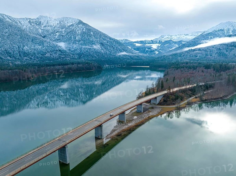 Road with bridge on the water in winter