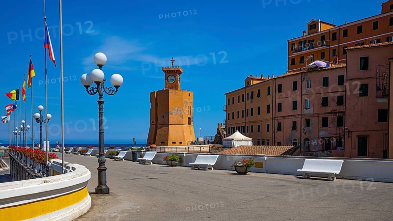 Lighthouse next to houses in pastel-coloured facades