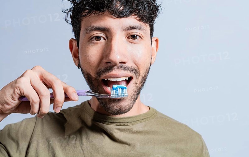Close up of man brushing his teeth isolated