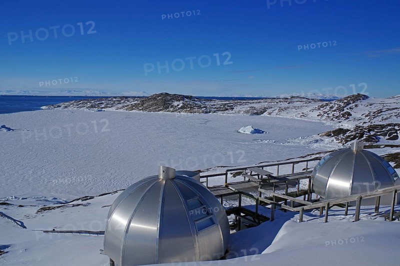 Futuristic metal igloo shelters in a wintry landscape