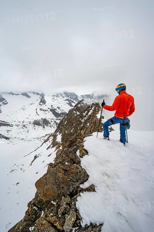 Ski tourers on rocky ridge with snow