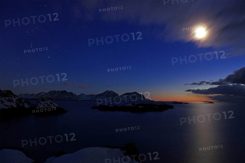 Moonlight over a wintry fjord landscape