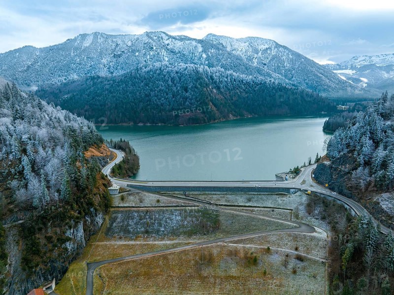 Road with dam on the water in winter