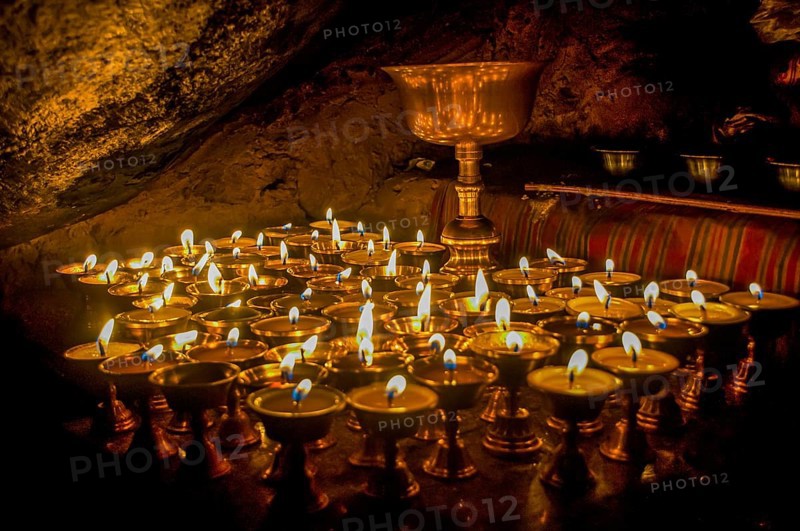 Cave with candles and Buddha images along the Kailash Kora