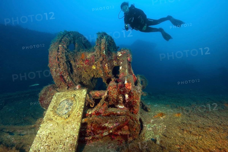 Diver dives hovering over shipwreck forecastle with windlass from wreck Mohawk Deer