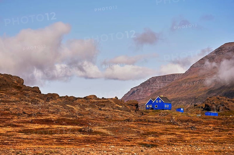 Blue wooden houses standing in volcanic landscape