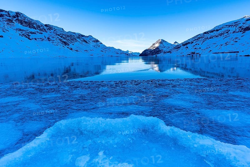 Ice structures in the black ice of the frozen Lago Bianco in the Swiss mountains