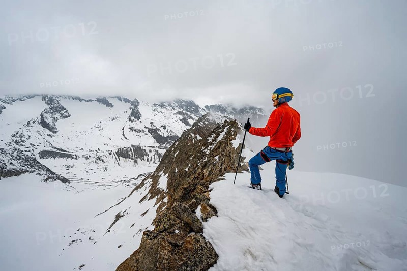 Ski tourers on rocky ridge with snow