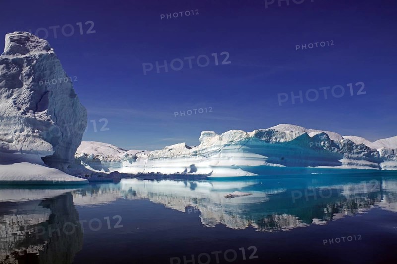 Icebergs reflected in a fjord