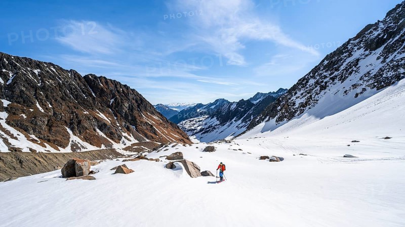 Ski tourers ascending along the glacier moraine to Berglasferner
