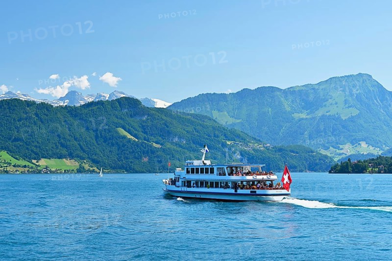 Motorboat Weggis cruises on Lake Lucerne in sunny weather.