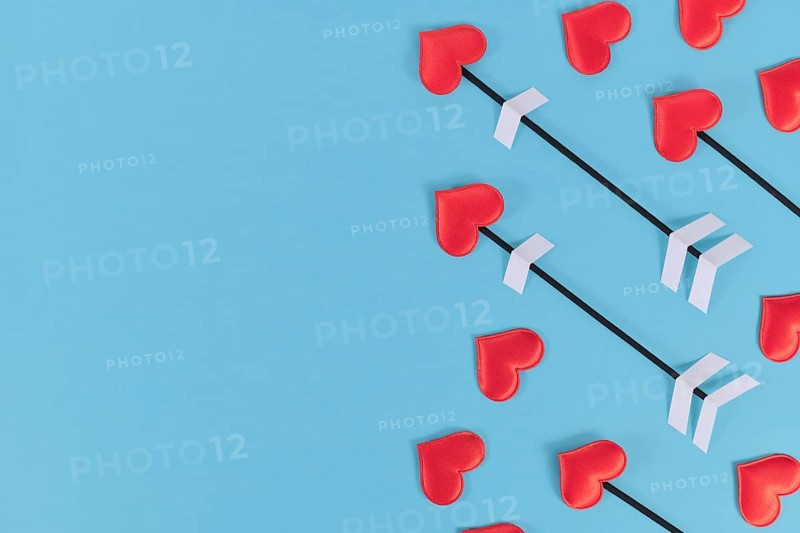 Valentine's day flat lay with cupid's love arrows on blue background with copy space