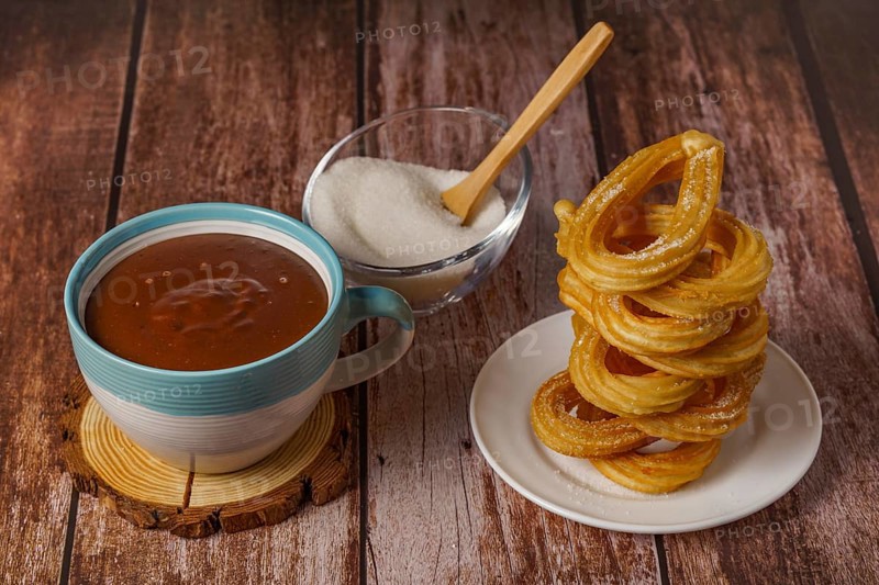 Hot chocolate with churros in a white and blue cup