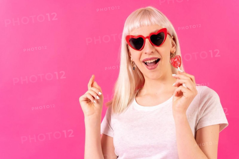 Blonde caucasian girl in studio on pink background
