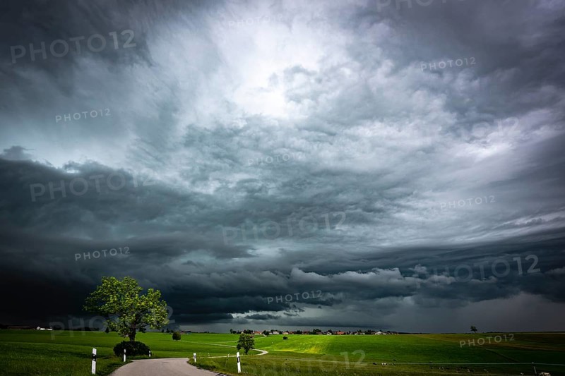 Road and meadows with thunderstorm sky in the background