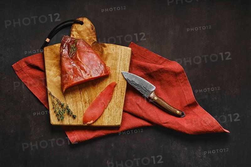 Top view of air dried turkey breast on wooden cutting board with place for text