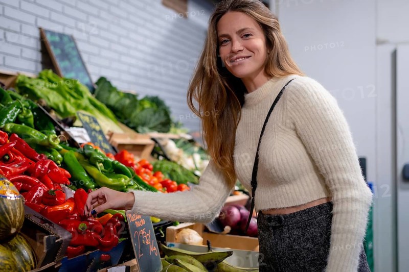 Vegetarian woman buying vegetables and greens in grocery store