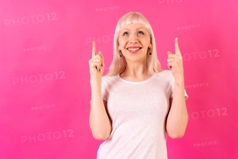 Blonde caucasian girl on pink studio background