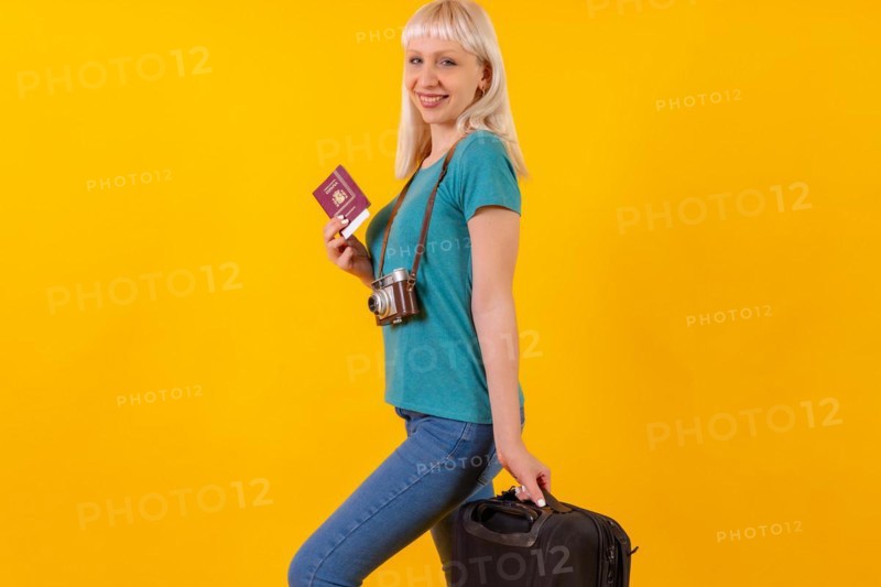 Smiling tourist with suitcase and passport