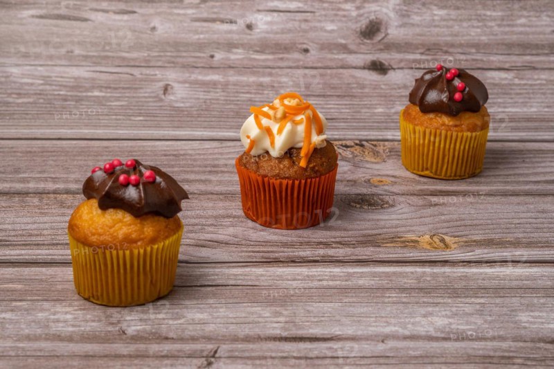 Assortment of chocolate and cream and carrot cupcakes on various backgrounds