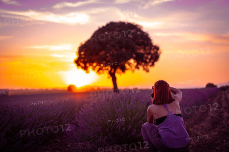 A woman at sunset in a lavender field with purple flowers