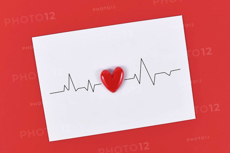 Heart and heartbeat line on white paper note on red background