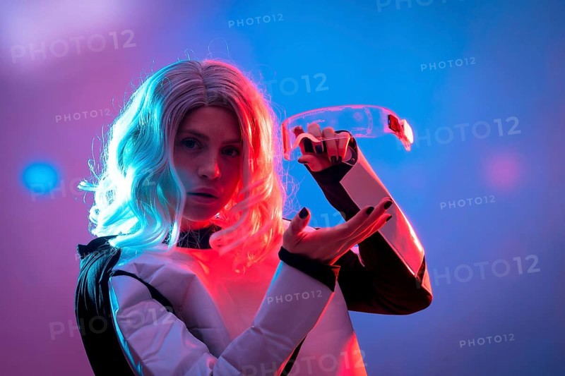 Beautiful woman showing futuristic glasses on a dark background